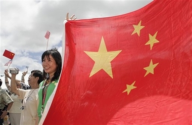 Lu Lu, a student at the University of Hawaii, holds a Chinese flag welcoming the Chinese navy ships docking at Naval Station Pearl Harbor, Wednesday, Sept. 6, 2006, in Pearl Harbor, Hawaii. The Qingdao, a Luhu-class guided missile cruiser, and the Hongzehu, a refueling ship, arrived for four days of exercises, personnel exchanges, and touring.