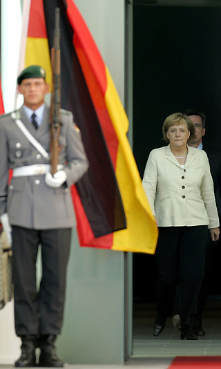 German Chancellor Angela Merkel walks past a soldier of a honour guard before the arrival of Chinese Prime Minister Wen Jiabao in front of the Chancellery in Berlin September 14, 2006. 