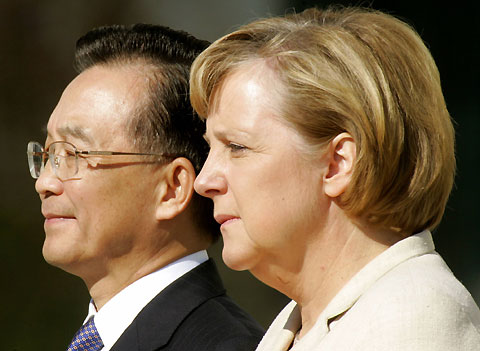German Chancellor Angela Merkel and Chinese Prime Minister Wen Jiabao (L) listen to the national anthems during a welcome ceremony in front of the Chancellery in Berlin September 14, 2006.