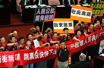 Legislators of Taiwan's opposition party carry banners and placards calling for Taiwan's Premier Su Tseng-chang and President Chen Shui-bian to step down at the first legislative assembly in Taipei September 19, 2006. 