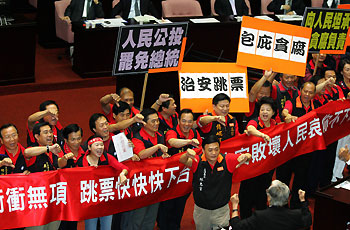 Legislators of Taiwan's opposition party carry banners and placards calling for Taiwan's Premier Su Tseng-chang and President Chen Shui-bian to step down at the first legislative assembly in Taipei September 19, 2006.