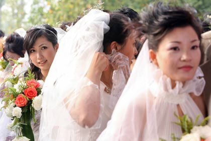 Some of 70 couples stand in a queue during a mass wedding event in Shanghai October 5, 2006. Some 2,000 couples registered their marriage this Monday in Shanghai, according to statistics, and there is an estimated 30,000 couples to hold their weddings during the seven-day holiday period or the 'Golden Week' holiday, Xinhua news agency said.