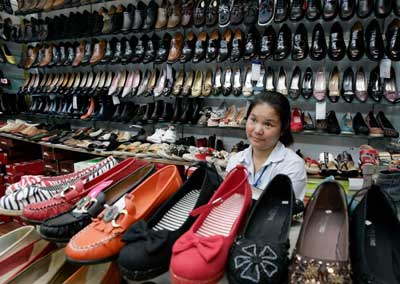 A shopkeeper waits for customers at a shoe store in Beijing August 31, 2006.