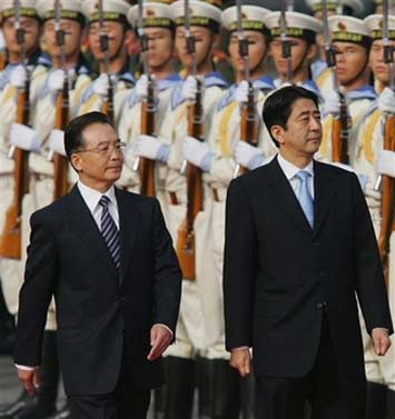 Chinese Premier Wen Jiabao (R) and Japanese Prime Minister Shinzo Abe review a guard of honor during a welcoming ceremony at the Great Hall of the People in Beijing, Sunday, Oct. 8, 2006. The visit by Abe marks the first formal summit between the countries' leaders in five years, after China canceled previous meetings to protest pilgrimages to a Tokyo war shrine by Abe's predecessor, Junichiro Koizumi. [AP Photo]