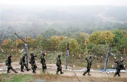 South Korean Army soldiers patrol along the barbed-wire fence in Paju, north of Seoul, near the demilitarized zone (DMZ) of Panmunjom, South Korea, Monday, Oct. 9, 2006. South Korea's Defense Ministry said the alert level of the military had been raised in response to the claimed nuclear test. (AP Photo