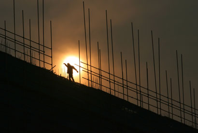 A labourer works on scaffoldings at a construction site in Nanjing, east China's Jiangsu province October 11, 2006. China's economic growth is likely to slow modestly to around 10 percent in 2007 from 10.5 percent this year as government tightening measures kick in, a top government think-tank said in a report published on Wednesday.