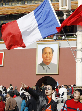 Visitors gather near a French national flag displayed at the gate of the Forbidden City in Beijing October 25, 2006. French President Jacques Chirac is seeking to build on a decade of warming diplomacy between Beijing and Paris as he starts what may be his last state visit to China on Wednesday.