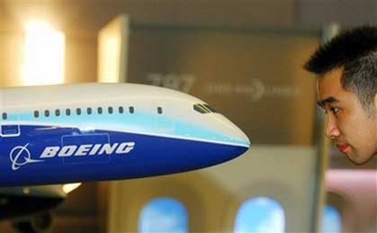 A visitor looks at a model of Boeing 787 Dreamliner in Shanghai, east China, on Thursday October 19, 2006. Boeing 787 Dreamnliner is a kind of plane under development currently and Chinese airlines have ordered 60 Boeing 787 freighters in all. [Xinhua]