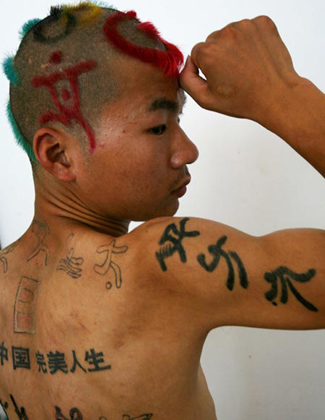 A man displays his 2008 Beijing Olympic Games icon tattoos and Olympic-themed hairstyle at a beauty salon in Hangzhou, east China's Zhejiang province August 31, 2006. 