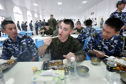 US Marines eat Chinese food with Chinese Marines on Friday at the canteen of a navy base in Zhanjiang, a port city in South China's Guangdong Province. The US Marines and warship USS Juneau, led by US Pacific Fleet Commander Gary Roughead, are going to participate in a joint search-and-rescue exercise with the Chinese navy in the South China Sea on Sunday. 
