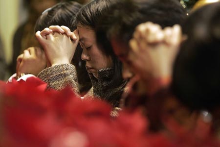 Christians pray at the Henshanlu church during a Christmas eve mass in Shanghai December 24, 2006. 