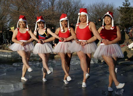 People dressed in Santa Claus costumes dance as they celebrate the upcoming Christmas Day at a park in Shenyang, capital of northeast China's Liaoning province December 23, 2006. 