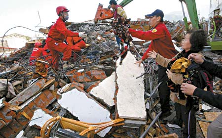 Rescue workers search for survivors at a collapsed building in southern Pingtung county December 27, 2006 after a strong earthquake shook Taiwan. Two people were killed and 42 injured when three buildings collapsed in earthquakes that shook southern Taiwan, authorities said on Wednesday. [Reuters]