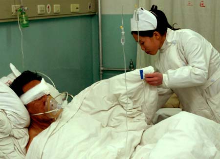 A nurse attends to a man injured during the explosion in a residential area at a hospital in Ulanqab City, North China's Inner Mongolia Autonomous Region, December 28, 2006. Five people died and eight were injured in two consecutive explosions in Jining District of Ulanqab City, Xinhua reported. A preliminary investigation said the accident was caused by detonator explosion. [Xinhua]
