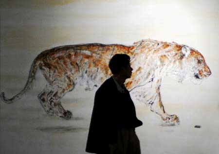 A visitor walks in front of a painting of tiger on display at Chinese People Museum in Xiamen, East China's Fujian Province, December 30, 2006. The museum marked the opening on Saturday after 400 days' construction and had a display of paintings and sculptures. [newsphoto]