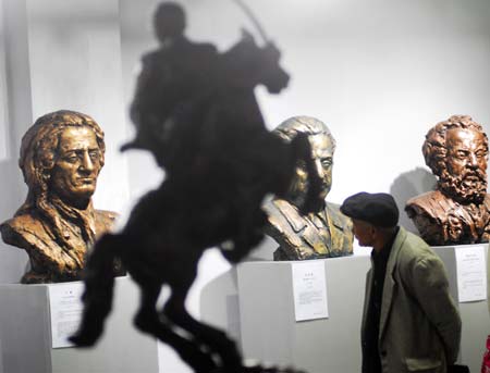 A visitor looks at the sculptures on display at Chinese People Museum in Xiamen, East China's Fujian Province, December 30, 2006. The museum marked the opening on Saturday after 400 days' construction and had a display of paintings and sculptures. [newsphoto]