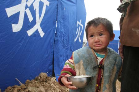 A boy cries after he and his family were moved into tents following a cave-in at Haijie Village, Nuotong Township, Guangxi Zhuang Autonomous Region, January 3,2007. The cave-in was caused by underground work on a nearby railway tunnel. Nobody was injured in the accident and some 257 villagers were evacuated to safe areas. [newsphoto]