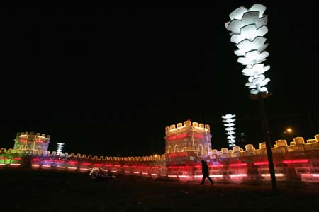 A man walks along an ice sculpture modelled after the Great Wall of China for the upcoming the China Harbin international ice and snow festival in Harbin, northeastern China's Heilongjiang Province, January 4, 2007.