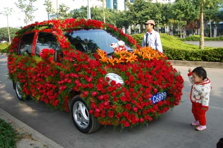A bride poses for a picture with a car decorated with flowers in Nanjing, South China's Guangxi Zhuang Autonomous Region January 7, 2007. [newsphoto]