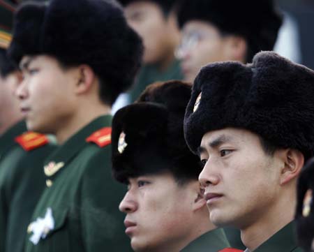 Chinese soldiers attend the memorial service for Huang Qiang, a 21-year-old policeman who died in a raid to a terrorist camp,in Urumqi,northwest China's Xinjiang Uygur Autonomous Region, January 9, 2007. Police have destroyed a terrorist camp in the mountains of Pamirs plateau in south Xinjiang, killing 18 terrorists and capturing 17 others.[newsphoto]