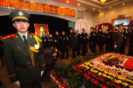 Mourners file past the casket of Huang Qiang, a 21-year-old policeman who died in a raid to a terrorist camp, during a memorial service in Urumqi, northwest China's Xinjiang Uygur Autonomous Region, January 9, 2007. Police have destroyed a terrorist camp in the mountains of Pamirs plateau in south Xinjiang, killing 18 terrorists and capturing 17 others.[newsphoto]