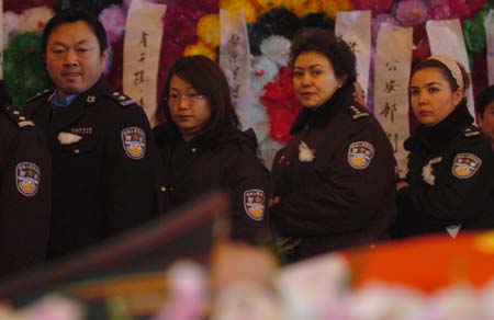 Chinese police officers pay their respect as they walk past the casket of Huang Qiang, a 21-year-old policeman who died in a raid to a terrorist camp, during a memorial service in Urumqi, northwest China's Xinjiang Uygur Autonomous Region, January 9, 2007. Police have destroyed a terrorist camp, killing 18 terrorists and capturing 17 others.