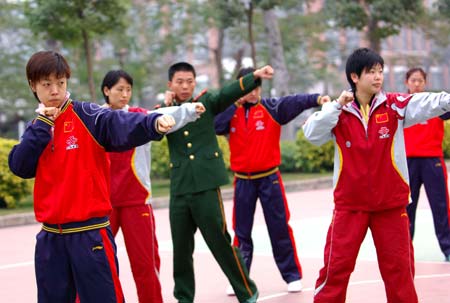 Zhang Yining (L) and other players of China's National Women Tennis Team practice under the guidance of a military official (3rd L) during one-month intensive training in Zhongshan, South China's Guangdong Province, January 11, 2007. The players received the military training once a week during their training in Zhonshan. [Xinhua]