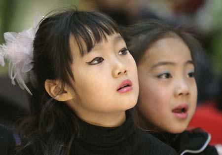 Participants in a child modelling competition watch the performance of other contestants in Beijing January 13, 2007. The competition was held at the end of a model training course for about 200 children aged 4 to 16, during which they underwent physical training and received instruction on stagecraft and various kinds of dances such as step dance and ballet. 