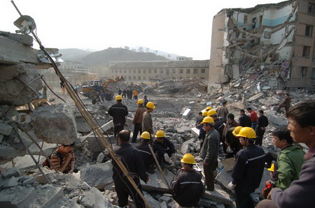 Rescue workers inspect the site of an explosion at a hospital in North China's Shanxi Province, April 10, 2006. The explosion killed 33 people.[Ma Liming/Shanxi Evening News]
