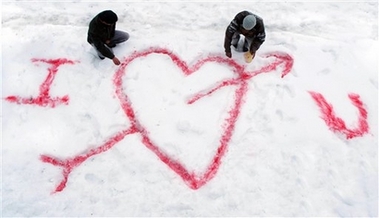 Boys write a message with red colored powder on snow to mark Valentine's Day in Shimla, India, Wednesday, Feb. 14, 2007.