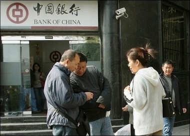 Chinese blackmarket moneychangers trade foreign currency with two customers outside a branch of the Bank of China in Shanghai. Germany, the host nation of this weekend's G7 finance summit, has insisted that exchange rates would figure in the discussions of the Group of Seven finance ministers and central bank chiefs.(AFP