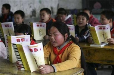 Pupils read from textbooks at a rural elementary school in the outskirt of southwest China's Chongqing municipality February 28, 2007. [Reuters]