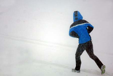 A man walks through a street during heavy snowfall in Shenyang, Northeast China's Liaoning Province, March 4, 2007. Most vehicles in Shenyang are forbidden to hit the road on Monday except those for public use to ensure the smooth cleanup and transportation of snow, which hit the city on Saturday night and caused major traffic troubles. [Xinhua]