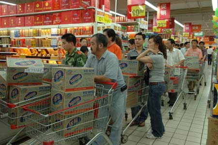 Customers queue to buy bottled water at a supermarket in Wuxi, East China's Jiangsu Province, May 30, 2007. Local residents in Wuxi rushed to buy bottled water when the tap water developed a strange smell. The blue-green algae outbreak in Taihu Lake affected the underground water in Wuxi and caused the water crisis, Xinhua said. [newsphoto]