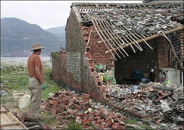 A man inspects flood damage to his house in southeast China's Fujian province, 2006. 