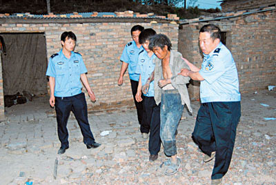 Chinese policemen help a young worker to leave a brick kiln in Hongtong County, Linfen City, North China's Shanxi Province in late May 2007. [Shanxi News Net]