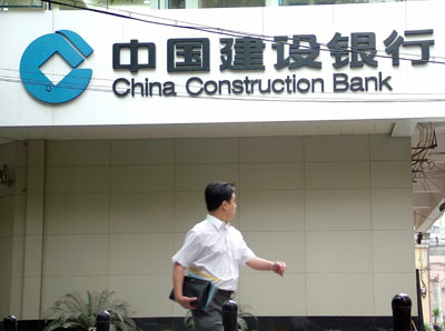 A pedestrian walks past a branch of China Construction Bank in Shanghai June 3, 2007. [newsphoto]