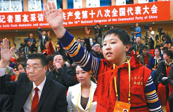 Zhang Jiahe, 11, a reporter from Chinese Teenagers News, attracts the attention of Minister of Housing and Urban-Rural Development Jiang Weixin during a news conference. 'Over here'
