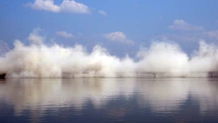 The Jiaji Bridge across the Wanquan River is dynamited in Qionghai, south China's Hainan Province, Nov. 30, 2007. A new bridge will be built on the site of the demolished one, which was built in 1953, one of the earliest in the province. (Xinhua/Meng Zhongde)