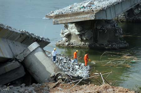 Photo taken on Nov. 30, 2007 shows the demolished Jiaji Bridge across the Wanquan River in Qionghai, south China's Hainan Province. The bridge, which was built in 1953, was dynamited on Nov. 30. A new bridge will be built on the site of the demolished Jiaji Bridge, one of the earliest in the province. (Xinhua/Meng Zhongde)