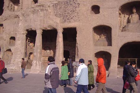 Visitors pass by the statues at the Yungang Grottoes in northern China's Shanxi Province in this photo, published on Dec. 31, 2007.