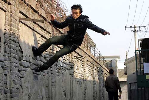 Du Yize, a young Chinese parkour fan, practices in a hutong (narrow alley) in Beijing. [Photo: China Photo Press]