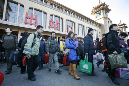 Chinese travellers carry their belongings upon arrival at Beijing Railway Station February 12, 2008. China is expected to see railway traffic peak on Tuesday, the last day of Spring Festival, as the Lunar New Year holiday is known, when millions head back to work from their hometowns. 'Post-Spring Festival railway traffic peak saw more than 5 million passengers in one day last year and we expect more in 2008,' Xinhua news agency quoted the Railways Ministry as saying. [Agencies]