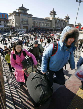 Chinese travellers carry their belongings upon arrival at Beijing Railway Station February 12, 2008. China is expected to see railway traffic peak on Tuesday, the last day of Spring Festival, as the Lunar New Year holiday is known, when millions head back to work from their hometowns. 'Post-Spring Festival railway traffic peak saw more than 5 million passengers in one day last year and we expect more in 2008,' Xinhua news agency on Monday quoted the Railways Ministry as saying. [Agencies]