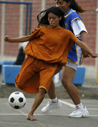A woman of the Ashaninka ethnic group kicks the ball during a soccer game against women employees of Lima's municipality during celebrations for International Women's Day in Lima, March 7, 2008. [Agencies]