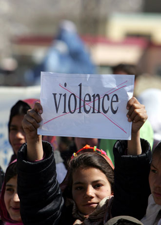 An Afghanistani girl holds a banner against violence during a protest in front of the parliament hall of Afghanistan. Saturday marks the United Nations International Women's Day around the world. [Xinhua]