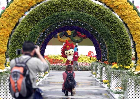 Journalists take pictures at the venue of the 2008 Hong Kong Flower Show in Hong Kong of south China on March 13, 2008. The show, organized by Hong Kong Leisure and Cultural Services Department, featuring exhibits of floral arrangements presenting the Beijing 2008 Olympic Games mascots, is scheduled to open on March 14 until March 24 in Victoria Park on Hong Kong Island. (Xinhua Photo)