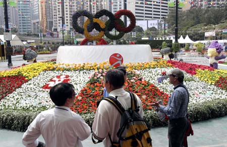 Technicians and journalists walk at the venue of the 2008 Hong Kong Flower Show in Hong Kong of south China on March 13, 2008. The show, organized by Hong Kong Leisure and Cultural Services Department, featuring exhibits of floral arrangements presenting the Beijing 2008 Olympic Games mascots, is scheduled to open on March 14 until March 24 in Victoria Park on Hong Kong Island.