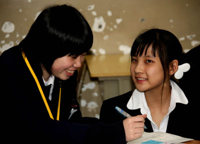 A Japanese student (L) talks with her Chinese peer in Japanese in Beijing, March 14, 2008. About 200 Japanese students and their Chinese peers held a 'communication day' in Beijing on Friday, to explore ways to enhance mutual understanding and friendship between youngsters from the two countries. [Xinhua]