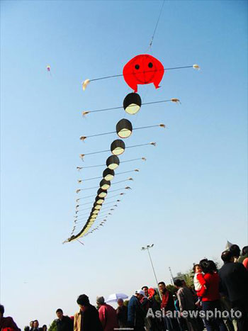 Local people watch a kite featuring a centipede flying in the sky in Hankou, Central China's Hubei province, March 23, 2008. A kite flying contest with the theme of Beijing Olympics was held there. [Asianewsphoto]
